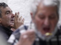 Homeless people smoke and have a meal at the homeless shelter The Crypt in Vienna