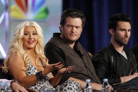 Aguilera answers a question as Shelton and Levine watch during the panel for the NBC television series "The Voice" in Pasadena