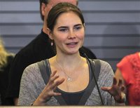 Amanda Knox gestures while speaking during a news conference at Sea-Tac International Airport, Washington