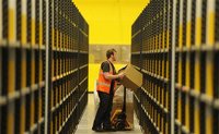 A worker lifts a box at Amazon's new fulfilment centre after it was opened by Scotland's First Minister Alex Salmond in Dunfermline