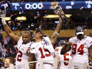 New York Giants (and former Michigan State) wide receiver Devin Thomas (C) holds the Vince Lombardi Trophy and celebrates with teammates Osi Umenyiora (L) and Mathias Kiwanuka after the Giants defeated the New England Patriots in the NFL Super Bowl XLVI football game in Indianapolis, Indiana, February 5, 2012.
REUTERS/Mike Segar