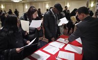 People talk with a job recruiter while they attend the "JobEXPO" job fair in New York