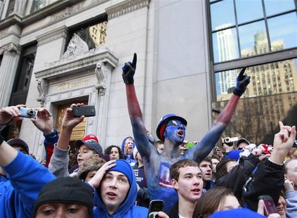 People celebrate during the New York Giants ticker tape Super Bowl victory parade through the Canyon of Heroes along Broadway in New York