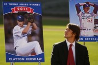 Los Angeles Dodgers' Kershaw stands next to his poster after winning the National League Cy Young Award in Los Angeles