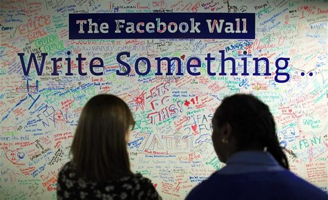 People look at the Facebook wall at their office in New York People look at the Facebook wall at their office in New York