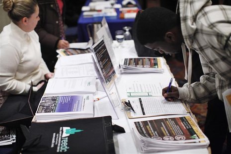 A man writes down his details at a booth during the "JobEXPO" job fair in New York A man writes down his details at a booth during the "JobEXPO" job fair in New York