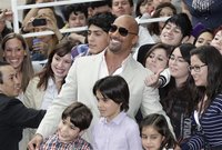 Actor Dwayne Johnson poses with fans after his arrival on the red carpet event to promote his new movie "Journey 2: The Mysterious Island" i