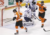 Flyers center Giroux and Flyers winger Jagr celebrate Girouxs goal against the Maple Leafs goalie Reimer during their NHL ice hockey game in