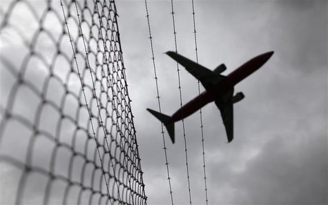 Passenger plane flies over a barbed wire fence Passenger plane flies over a barbed wire fence