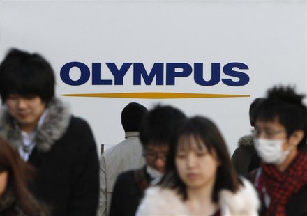 People walk past a signboard of Olympus Corp outside its showroom in Tokyo People walk past a signboard of Olympus Corp outside its showroom in Tokyo
