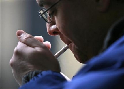 A smoker lights a cigarette in downtown Toronto A smoker lights a cigarette in downtown Toronto