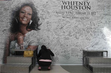 A Filipino fan writes a message on a tribute wall for the late American singer-actress Whitney Houston in Manila A Filipino fan writes a message on a tribute wall for the late American singer-actress Whitney Houston in Manila