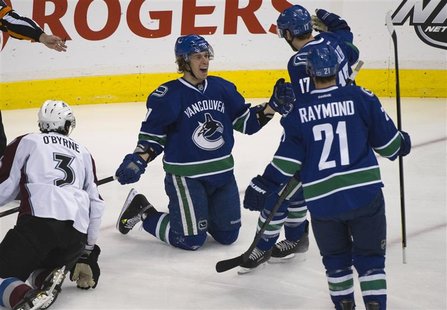 Vancouver Canucks' Booth celebrates goal against Colorado Avalanche with teammates Raymond and Kesler during NHL hockey in Vancouver Vancouver Canucks' Booth celebrates goal against Colorado Avalanche with teammates Raymond and Kesler during NHL hockey in Vancouver