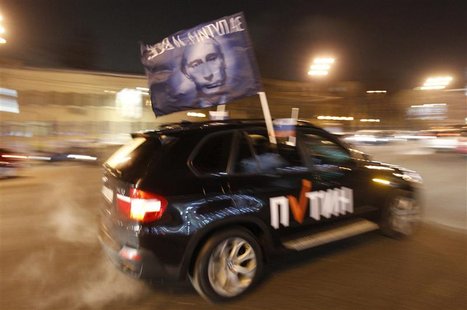 A car drives with a flag showing a portrait of Russian Prime Minister Vladimir Putin during a car rally to show support for Putin's presiden A car drives with a flag showing a portrait of Russian Prime Minister Vladimir Putin during a car rally to show support for Putin's presiden