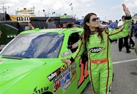 NASCAR Sprint Cup Series driver Danica Patrick (R) waves to fans while rolling her number 10 car out to the track before a practice session 
