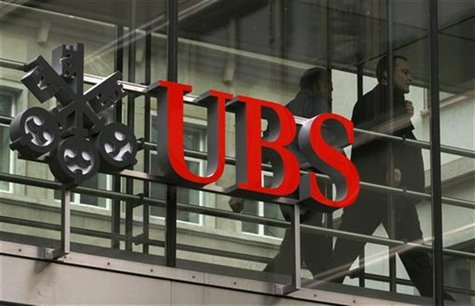 People walk behind the logo of Swiss bank UBS in Zurich People walk behind the logo of Swiss bank UBS in Zurich