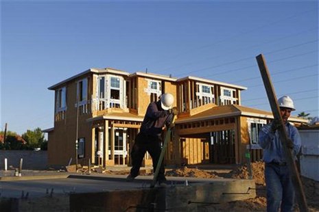 Workers remove wood panels from the foundation of a house being constructed in Phoenix