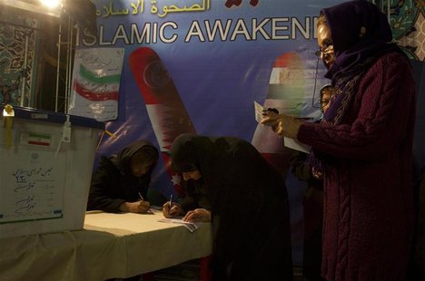 Women fill in their ballots beside the box during the final minutes before the 11pm closure of polls for the parliamentary election in a mos Women fill in their ballots beside the box during the final minutes before the 11pm closure of polls for the parliamentary election in a mos