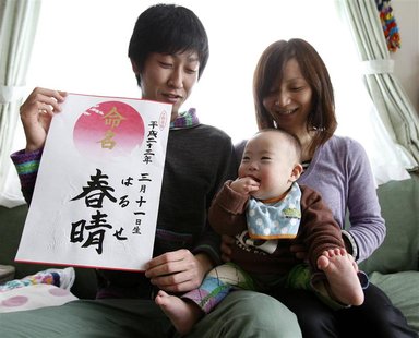 Hiromi Sato holds her son next to her husband during a photo opportunity at their home in Minamisanriku Hiromi Sato holds her son next to her husband during a photo opportunity at their home in Minamisanriku