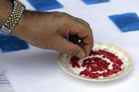A stock image shows a man handling Methamphetamine in a drug raid. Photo courtesy of Reuters. A stock image shows a man handling Methamphetamine in a drug raid. Photo courtesy of Reuters.