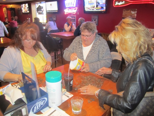 B93 sales team counting change from two little kids piggy bank donation.