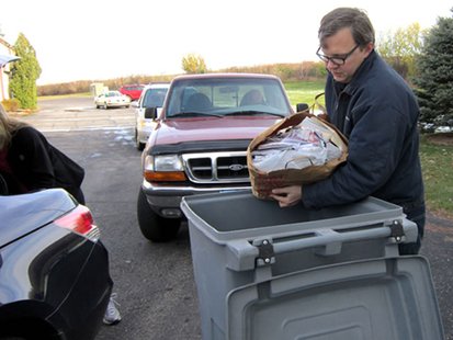 An employee of Access Information Management dumps paper into the shredding bins. (courtesy of Wisconsin Department of Agriculture, Trade and Consumer Protection). An employee of Access Information Management dumps paper into the shredding bins. (courtesy of Wisconsin Department of Agriculture, Trade and Consumer Protection).