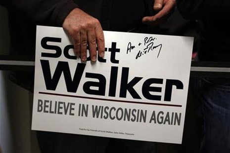 A supporter holds a sign autographed by U.S. Republican presidential candidate Mitt Romney after he attended a phone bank on behalf of Wisco A supporter holds a sign autographed by U.S. Republican presidential candidate Mitt Romney after he attended a phone bank on behalf of Wisco