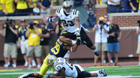 Jordan White(83) hurdles a Michigan defender. Jordan White(83) hurdles a Michigan defender.