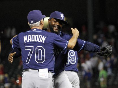 Tampa Bay Rays pitcher Fernando Rodney (R) is congratulated by manager Joe Maddon (L) after making the final out against the Texas Rangers i Tampa Bay Rays pitcher Fernando Rodney (R) is congratulated by manager Joe Maddon (L) after making the final out against the Texas Rangers i