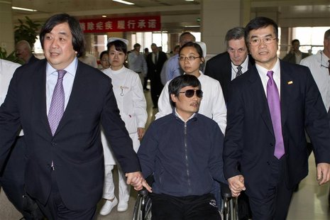 A handout photo from the U.S. Embassy Beijing Press office shows blind activist Chen Guangcheng (C) sitting in a wheelchair as he is accompa A handout photo from the U.S. Embassy Beijing Press office shows blind activist Chen Guangcheng (C) sitting in a wheelchair as he is accompa