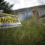 An auction sign for a property is seen at the front garden of a foreclosed house in Miami Gardens, Florida September 15, 2009. REUTERS/Carlo