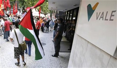 A man walks in front of the building of Brazilian miner Vale with a Palestinian flag during National Day to protest against job layoffs and A man walks in front of the building of Brazilian miner Vale with a Palestinian flag during National Day to protest against job layoffs and