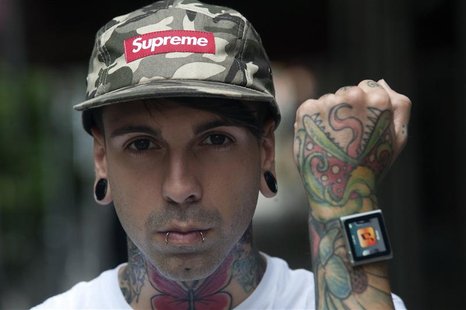 Tattoo artist Dave Hurban displays an iPod Nano which he has attached to his wrists through magnetic piercings in his wrist in New York, May Tattoo artist Dave Hurban displays an iPod Nano which he has attached to his wrists through magnetic piercings in his wrist in New York, May