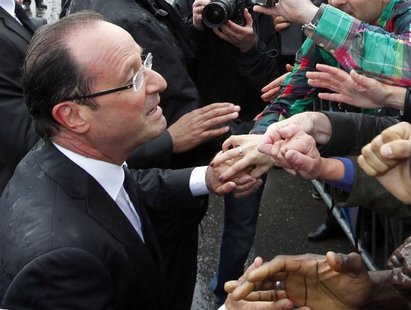 France's new President Francois Hollande (L) shakes hands with supporters on the Champs Elysees Avenue after the handover ceremony in Paris France's new President Francois Hollande (L) shakes hands with supporters on the Champs Elysees Avenue after the handover ceremony in Paris