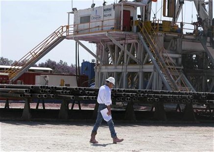 A Chesapeake Energy Corp. worker walks past stacks of drill pipe needed to tap oil and gas trapped deeply in rock like shale at a Chesapeake A Chesapeake Energy Corp. worker walks past stacks of drill pipe needed to tap oil and gas trapped deeply in rock like shale at a Chesapeake