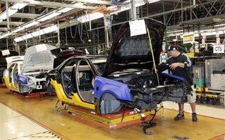 A General Motors assembly worker works on the production line for the 2011 Cadillac at the Grand River Assembly plant in Lansing, Michigan O