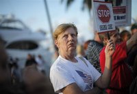 A resident of south Florida holds a sign protesting healthcare reforms during a visit by U.S. President Barack Obama to Miami, Florida, Octo
