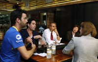 U.S. President Barack Obama talks with small business owners to discuss income tax credits during a roundtable discussion at Taylor Gourmet 