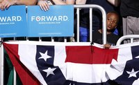 A young boy peers out as U.S. President Barack Obama speaks at a campaign rally at the Ohio State University in Columbus, Ohio May 5, 2012. 