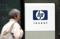 A woman walks past the Hewlett Packard logo at its French headquarters in Issy le Moulineaux, western Paris, in this September 16, 2005 file