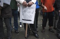 A protester in the Occupy Wall Street movement holds a protest sign with the face of JPMorgan CEO Jamie Dimon as he participates in a rally 