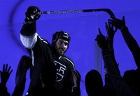 Los Angeles Kings left wing Dwight King hands a stick to fans after defeating the Phoenix Coyotes in Game 3 of the NHL Western Conference fi
