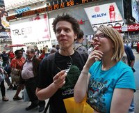 People gather outside the NASDAQ Marketsite waiting to see Facebook's share prices posted inside on video monitors in New York May 18, 2012.
