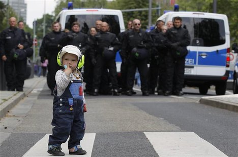 A child stands in front of German riot police officers during an anti-austerity demonstration in Frankfurt May 19, 2012. REUTERS/Alex Domans A child stands in front of German riot police officers during an anti-austerity demonstration in Frankfurt May 19, 2012. REUTERS/Alex Domans
