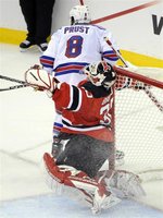 New Jersey Devils goalie Martin Brodeur reacts after being hit by New York Rangers' Brandon Prust during the second period in game 3 of thei