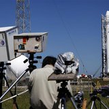 News photographers work on their remote cameras as the SpaceX Falcon 9 test rocket is being prepared for a second launch attempt from Space News photographers work on their remote cameras as the SpaceX Falcon 9 test rocket is being prepared for a second launch attempt from Space