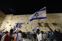 Israeli youths dance with national flags in front of the Western Wall, Judaism's holiest prayer site, during a parade marking Jerusalem Day 