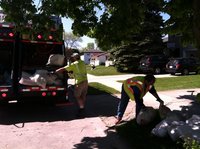 Sheboygan Mayor Terry Van Akkeren helps load garbage into a garbage truck Tuesday morning. 