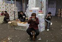 Vendors have lunch near boxes of fruits at a wholesale market in Wuhan, Hubei province April 9, 2012. REUTERS/Stringer