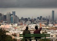 Two men look out over the San Francisco skyline from above Dolores Park, following a rain shower in San Francisco, California May 3, 2012. R